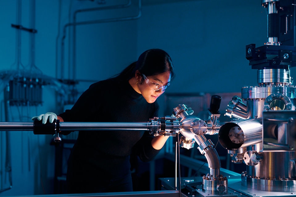 Thai student working in materials science laboratory using the high temperature scanning tunneling microscope while another student observes at UNSW Materials and Manufacturing Futures Institute (MMFI) .