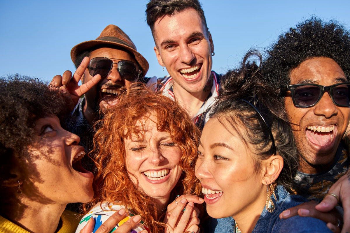 A group of international students are smiling and posing for a selfie