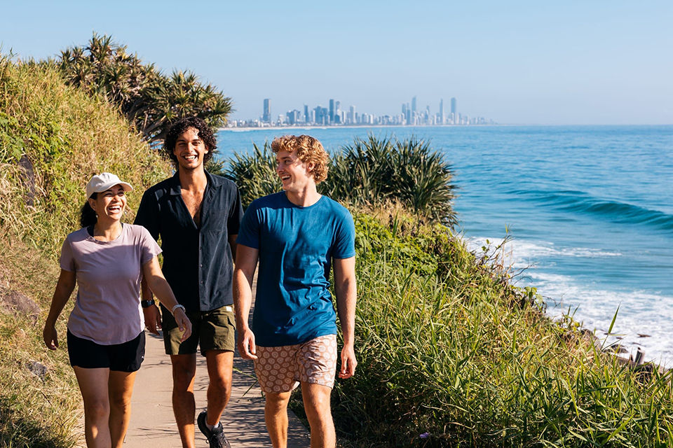 Group of friends walking along the oceanfront pathway through the National Park