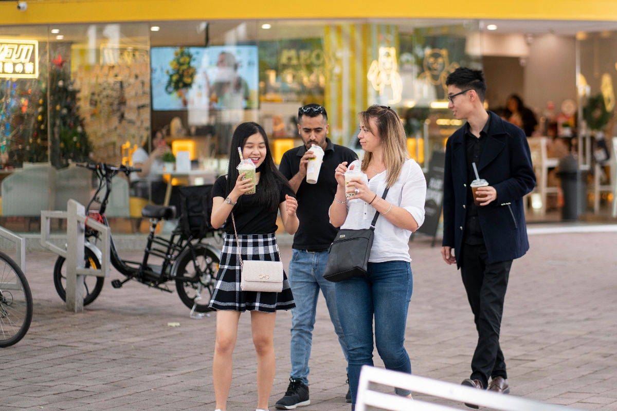 International students in a main street of Canberra, enjoying smoothies 