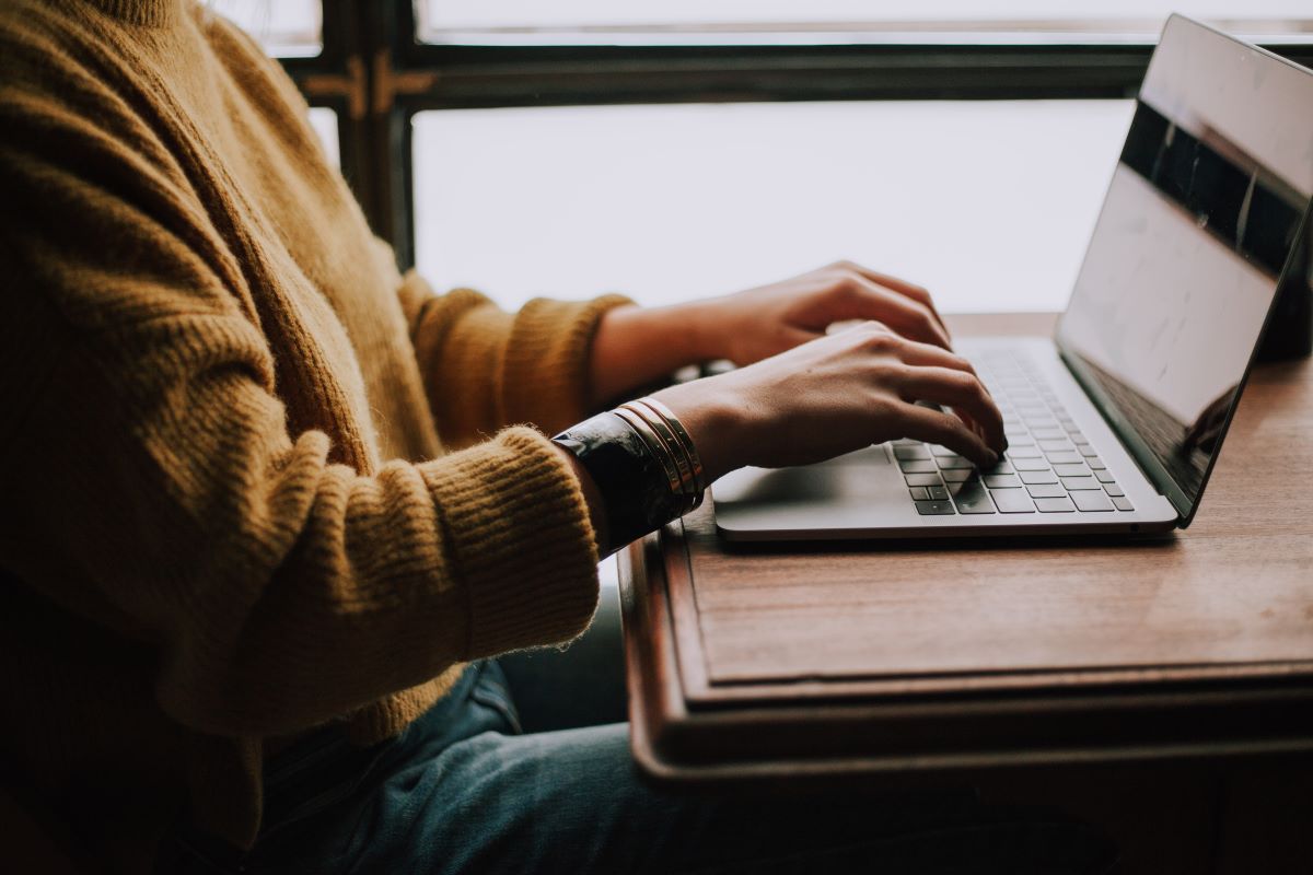 A close up of a person's hands using a laptop