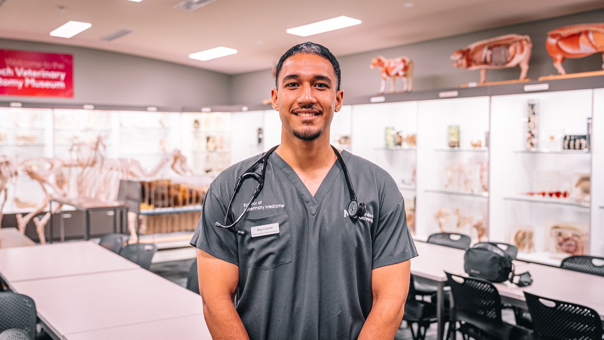 Roy standing in scrubs in a classroom