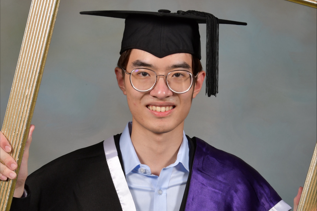 International student Henry, in his graduation cap and gown