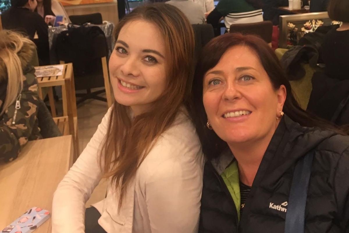 Iori and her host mother smiling at a restaurant table