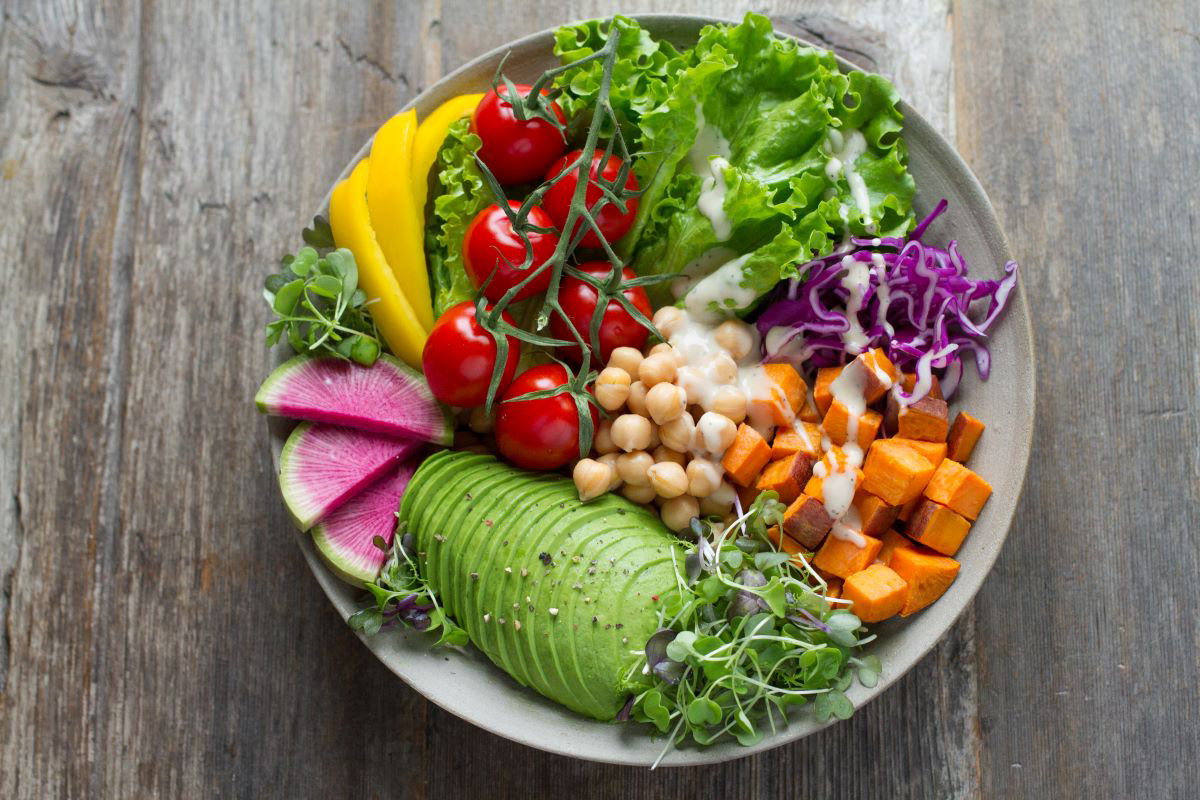 A white plate topped with a salad and vegetables