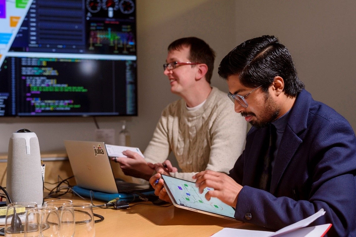 Shahzeb on his tablet with a work colleage beside him on his laptop
