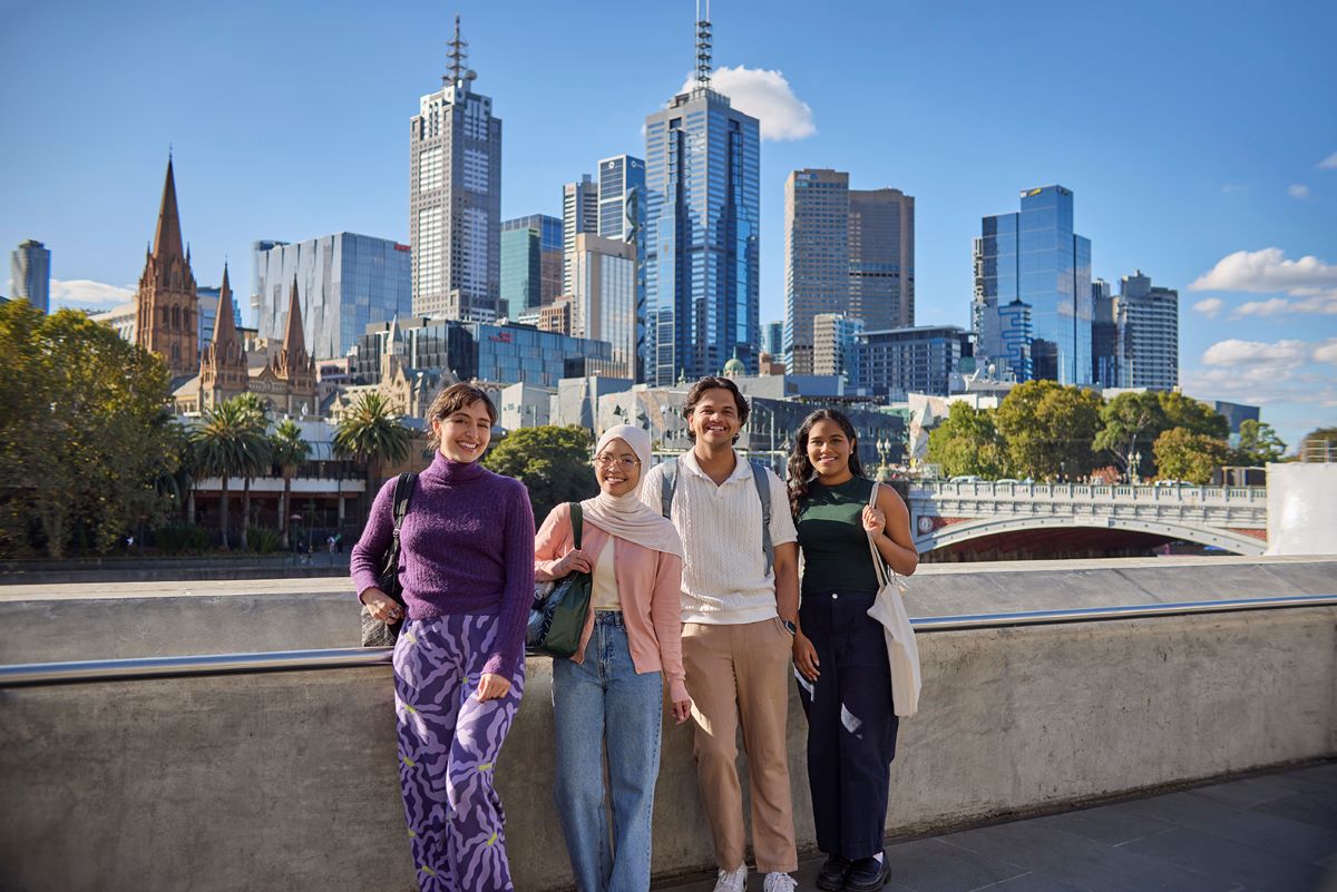 Four friends standing at Southbank with Melbourne city behind them