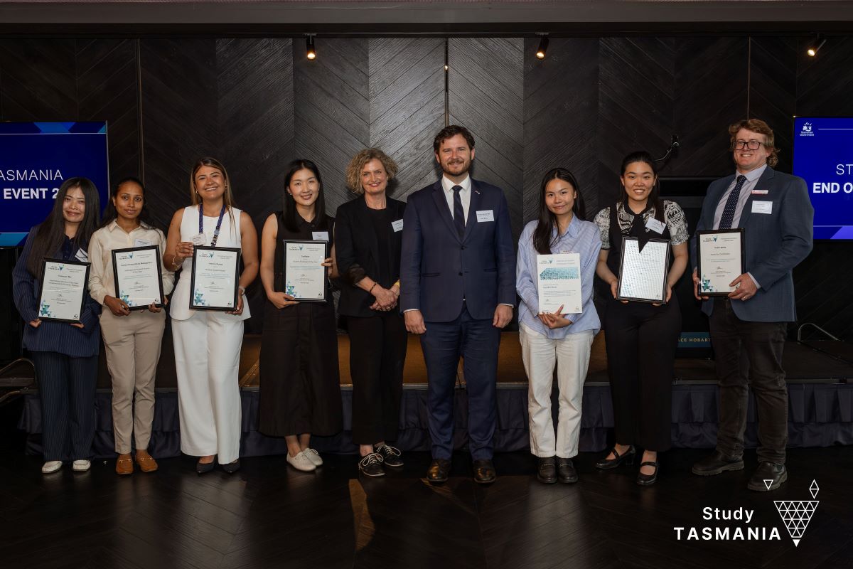 Award recipients standing with their certificates smiling.