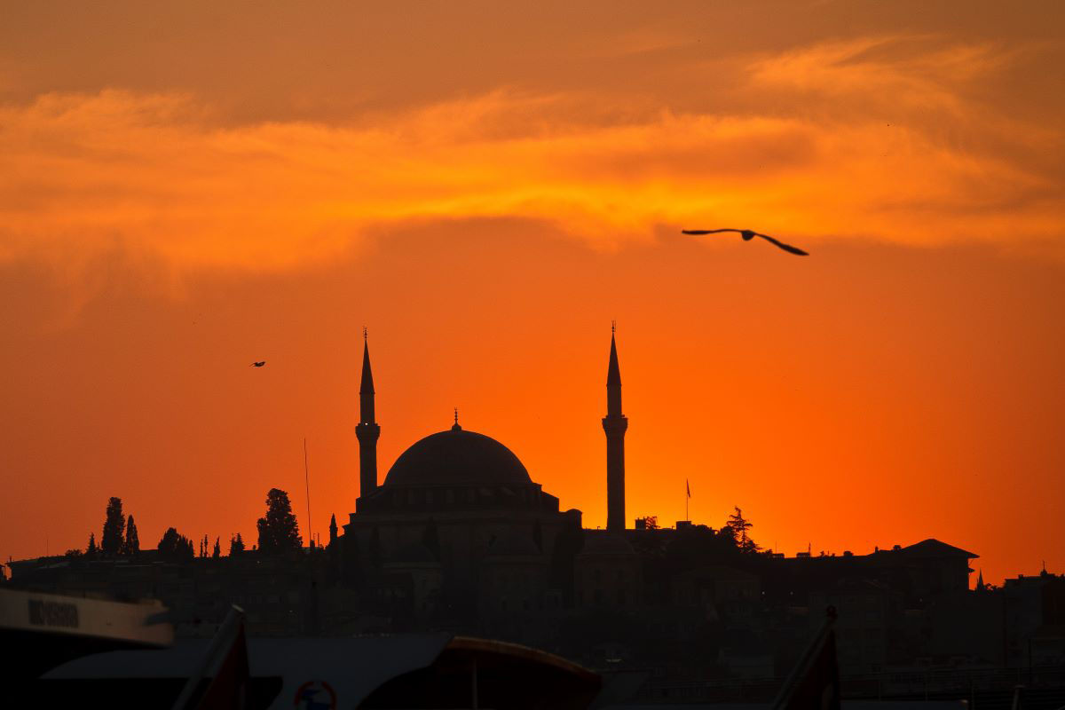 A mosque is silhouetted at sunset 